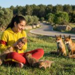 Riley Via playing with fox cubs near a rural road