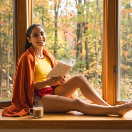 Riley Reads in a window during autumn